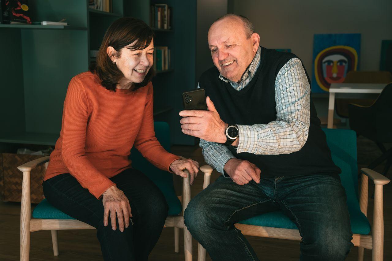 Muž a žena se dívají na mobil. Brzy bude každý člověk v Česku starší 65 let. Třetina z nich je digitálně vyloučená